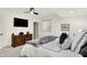 Well-lit bedroom with large bed, ceiling fan, neutral carpet, a dresser, and a side table at 19795 Chatham Shore Ln, Westfield, IN 46074