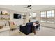 Upstairs bonus room features a fan, tv, built-in shelves, windows, and seating area at 19795 Chatham Shore Ln, Westfield, IN 46074