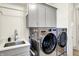 Laundry room featuring stainless steel washer and dryer and built-in cabinets at 19795 Chatham Shore Ln, Westfield, IN 46074