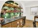 Custom wet bar has a sink, beverage fridge, wood countertops, and open shelves for bottles and decor at 19795 Chatham Shore Ln, Westfield, IN 46074