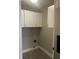 Laundry area with white cabinets, grey walls, and modern flooring at 2027 E Werges Ave, Indianapolis, IN 46237