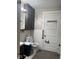 View of the bathroom with a toilet, sink, cabinet, door with coat rack, and mirror with lighting at 2122 George St, Anderson, IN 46016