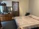 Bedroom with a patterned bedspread, wooden dresser, and window with curtains at 2122 George St, Anderson, IN 46016