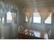 Sunny dining area with wooden table and decorative curtains at 2122 George St, Anderson, IN 46016