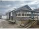 Exterior view of a gray-sided house with multiple windows and a concrete driveway leading to a detached garage at 2122 George St, Anderson, IN 46016