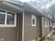 Home exterior with brown siding, white trim, and a concrete foundation at 2122 George St, Anderson, IN 46016