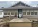Charming home featuring a decorative front door, neutral siding, and a welcoming entrance platform at 2122 George St, Anderson, IN 46016