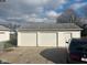 Two-car garage with white doors and a side entry door, situated on a concrete driveway at 2122 George St, Anderson, IN 46016