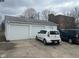 Detached two-car garage with white doors and concrete driveway, cars parked in front at 2122 George St, Anderson, IN 46016