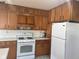 Well-lit kitchen featuring wooden cabinets and standard white appliances at 2122 George St, Anderson, IN 46016