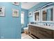 Bright blue bathroom with a double sink vanity, modern mirrors, and tasteful decor at 2224 E Pleasant Run Parkway North Dr, Indianapolis, IN 46203