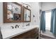 Bathroom featuring dual sinks, wood cabinets, and floral wallpaper at 2224 E Pleasant Run Parkway North Dr, Indianapolis, IN 46203