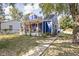 Side view of a blue home with a sidewalk leading up to a cozy front porch, surrounded by lush greenery at 2224 E Pleasant Run Parkway North Dr, Indianapolis, IN 46203