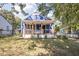 Charming blue home featuring a quaint front porch with stone accents and a well-maintained lawn at 2224 E Pleasant Run Parkway North Dr, Indianapolis, IN 46203