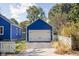 Exterior view of the detached blue garage featuring a white garage door with black hardware at 2224 E Pleasant Run Parkway North Dr, Indianapolis, IN 46203