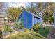 View of a blue outbuilding with a white roof with a yard and a garden area at 2224 E Pleasant Run Parkway North Dr, Indianapolis, IN 46203