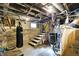 Basement with a punching bag and stairs leading to a small window and block wall at 2401 N Olney St, Indianapolis, IN 46218
