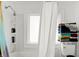 Well-lit bathroom with a tub/shower combination, white shower curtain, and built-in toiletry shelving at 2401 N Olney St, Indianapolis, IN 46218