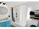 Bright bathroom featuring a tub with shower, white shower curtain, and shelving unit for linens at 2401 N Olney St, Indianapolis, IN 46218