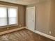 Bedroom with neutral carpeting, white door, and bright window at 2401 N Olney St, Indianapolis, IN 46218