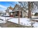 Charming two-story home featuring a welcoming front porch with brick accents and snow-covered yard at 2401 N Olney St, Indianapolis, IN 46218