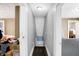 Narrow hallway with gray walls and hardwood floors connecting two rooms, featuring a central ceiling light at 2401 N Olney St, Indianapolis, IN 46218