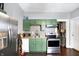 This kitchen offers stainless steel appliances, green cabinetry, and mosaic backsplash at 2401 N Olney St, Indianapolis, IN 46218