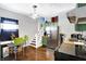 This kitchen has green cabinets, stainless steel appliances, and lots of natural light at 2401 N Olney St, Indianapolis, IN 46218
