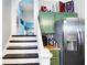 This kitchen has green cabinets and stainless steel appliances and a view of the stairs at 2401 N Olney St, Indianapolis, IN 46218