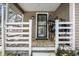 Front porch with a black security door, white railings, and snow on the ground at 2401 N Olney St, Indianapolis, IN 46218