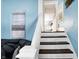 Inviting staircase with wooden treads and white risers, leading to a bright, airy hallway at 2401 N Olney St, Indianapolis, IN 46218