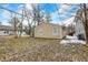 Backyard view showing the detached garage, small patches of snow, and deciduous trees on the property at 2402 Adams St, Indianapolis, IN 46218