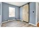 This bedroom features a sliding barn door, window, and light wood floors at 2402 Adams St, Indianapolis, IN 46218