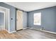 Bedroom featuring modern barn door, new flooring, and a window at 2402 Adams St, Indianapolis, IN 46218