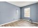 Cozy bedroom with light wood floors, a window, and blue-grey colored walls at 2402 Adams St, Indianapolis, IN 46218