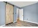 Light filled bedroom features a barn door and light wood floors at 2402 Adams St, Indianapolis, IN 46218