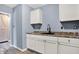 Kitchen featuring white cabinets, brown countertops, and modern fixtures at 2402 Adams St, Indianapolis, IN 46218
