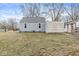 A backyard featuring a house with blue siding and a large grassy lawn in need of some care at 2420 Sheffield Ave, Anderson, IN 46011