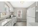 Well-lit kitchen with white appliances, laminate floors, and ample cabinet space at 2420 Sheffield Ave, Anderson, IN 46011