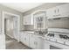 Bright kitchen showcasing white cabinetry, laminate countertops, and a stainless-steel sink at 2420 Sheffield Ave, Anderson, IN 46011