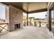 Covered patio with a brick fireplace and wood railing overlooking a neighborhood under construction at 3588 Marketplace Ct, Zionsville, IN 46077