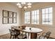 A modern dining room featuring a long wooden table, stylish chairs, bright windows, and botanical artwork at 3588 Marketplace Ct, Zionsville, IN 46077