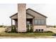 Side view of a two-story home with a covered porch and brick chimney, enhanced by new landscaping at 3588 Marketplace Ct, Zionsville, IN 46077