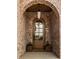 Close-up of arched front door with glass panes, planters, and a lantern light at 3588 Marketplace Ct, Zionsville, IN 46077