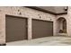 Attached two car garage with raised panel doors and charming sconce lighting near the arched entry at 3588 Marketplace Ct, Zionsville, IN 46077