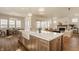 Open concept kitchen with island, farmhouse sink, and hardwood floors seamlessly flowing into living area at 3588 Marketplace Ct, Zionsville, IN 46077