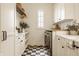 Bright laundry room featuring checkerboard floors, custom cabinets, and marble countertops, perfect for efficient organization at 3588 Marketplace Ct, Zionsville, IN 46077
