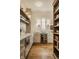 Charming pantry area with custom cabinetry, a beverage center, open wooden shelves and modern lighting fixtures at 3588 Marketplace Ct, Zionsville, IN 46077