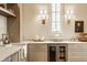 Charming pantry area with marble countertops, a beverage center, custom cabinetry and modern lighting fixtures at 3588 Marketplace Ct, Zionsville, IN 46077