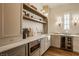Charming pantry area with marble countertops, a beverage center, custom cabinetry and modern lighting fixtures at 3588 Marketplace Ct, Zionsville, IN 46077